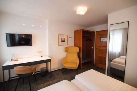 Standardzimmer im Hotel am Main mit Schreibtisch und Sessel